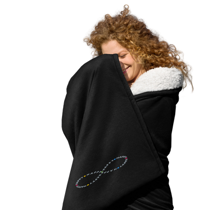 Happy young woman wrapped in soft black sherpa throw blanket with a happy embroidered infinity symbol HappyStuff