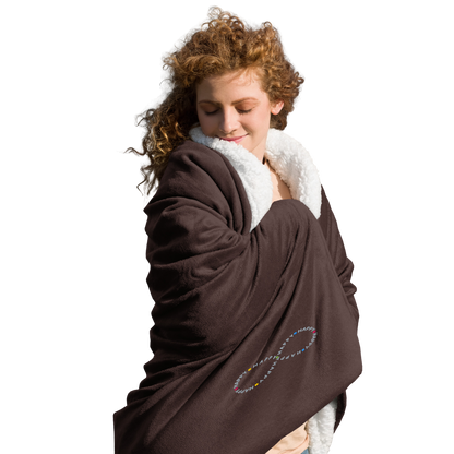 Cozy happy young woman wrapped in soft brown sherpa throw blanket with a happy embroidered infinity symbol HappyStuff