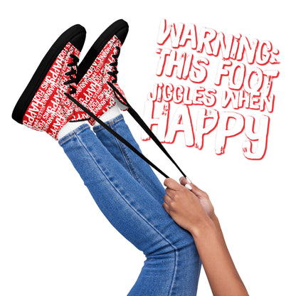 Womens feet in the air holding laces of HappyStuff red and white high tops fun print Warning This Foot Jiggles When Happy black sole