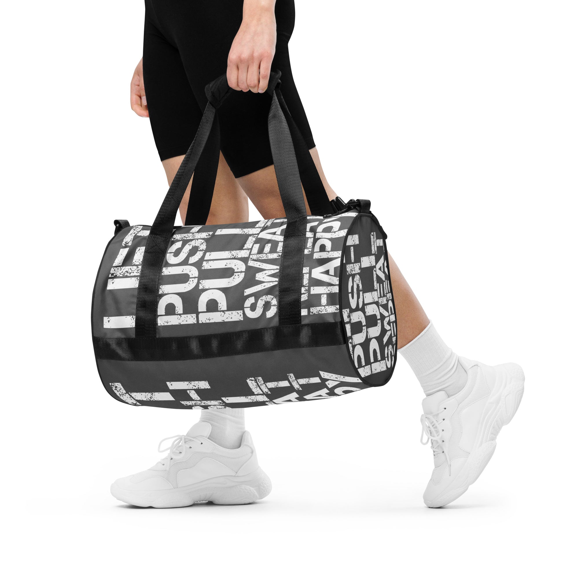 Woman carrying gym bag slate grey and white all over print Lift Push Pull Sweat Repeat Happy small duffle bag black detail HappyStuff Brand padded handles