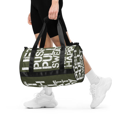 Woman carrying gym bag khaki green and white all over print Lift Push Pull Sweat Repeat Happy small duffle bag black detail HappyStuff Brand padded handles