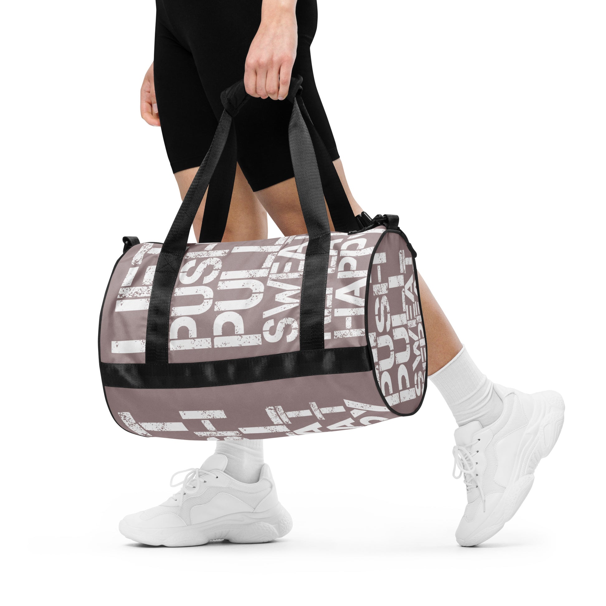 Woman carrying gym bag taupe and white all over print Lift Push Pull Sweat Repeat Happy small duffle bag black detail HappyStuff Brand padded handles