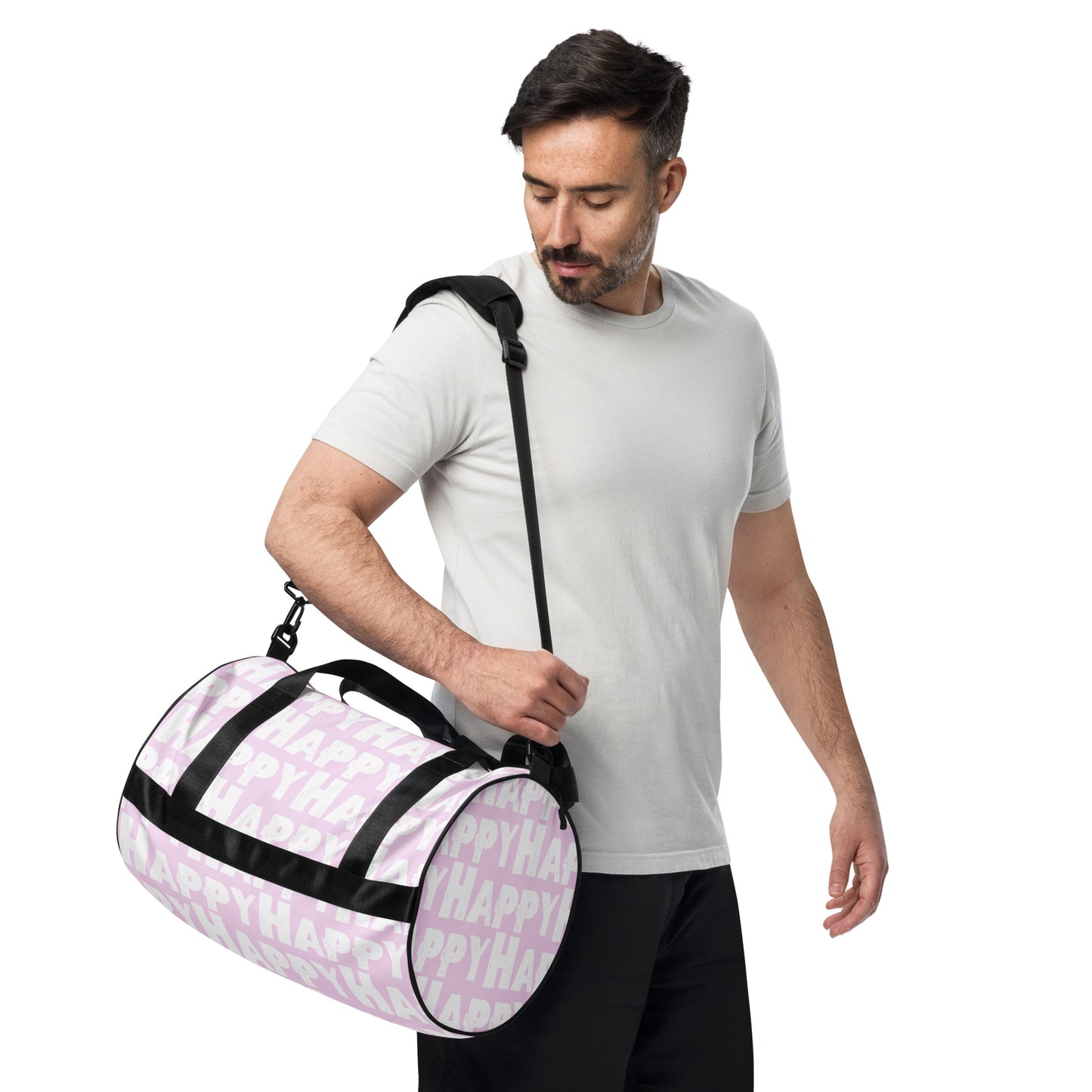 Man carrying gym bag adjustable removable padded shoulder strap Happy sponge print black white on pink small duffle bag HappyStuff Brand