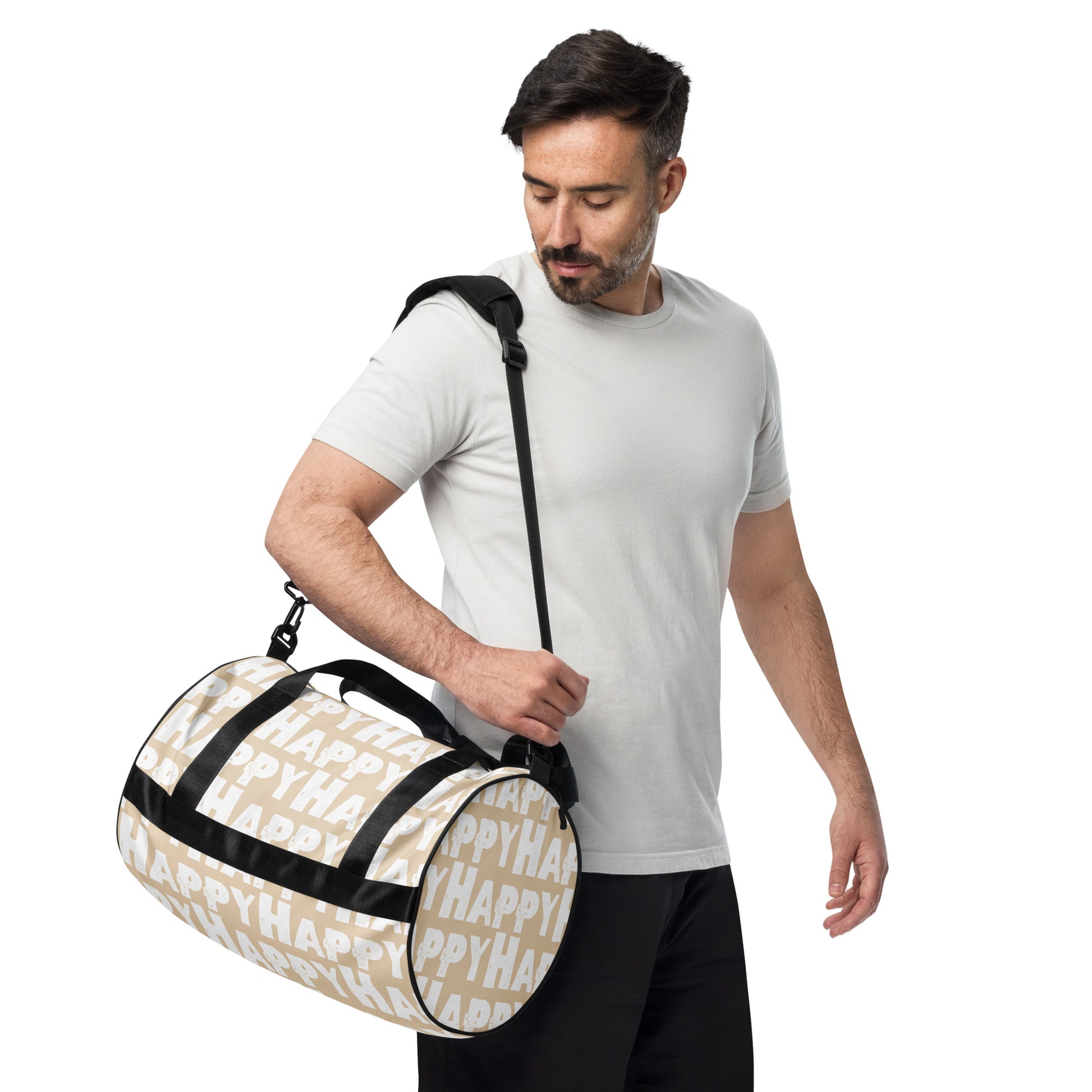 Man carrying gym bag adjustable removable padded shoulder strap Happy sponge print black white on beige small duffle bag HappyStuff Brand