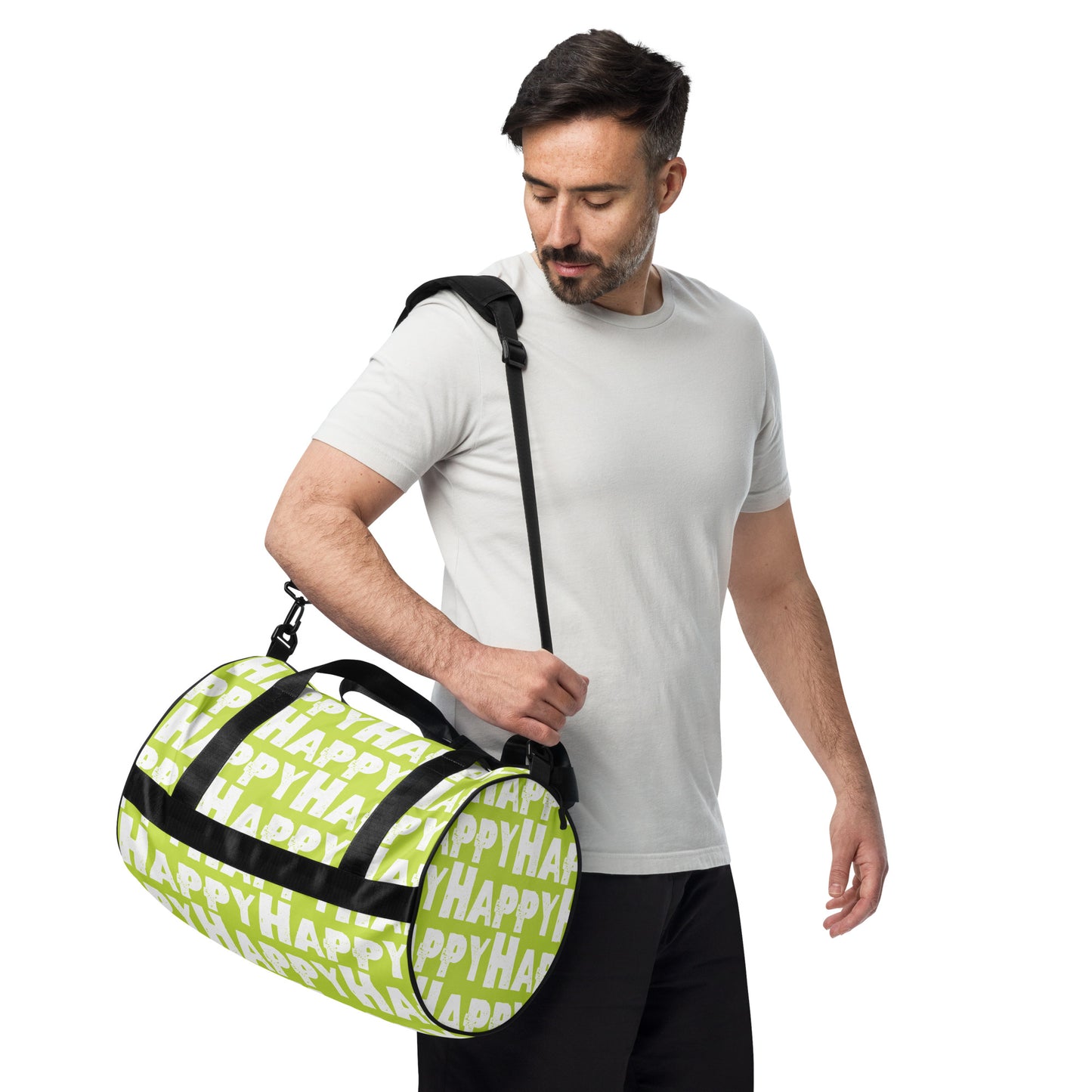 Man carrying gym bag adjustable removable padded shoulder strap Happy sponge print black white on green small duffle bag HappyStuff Brand