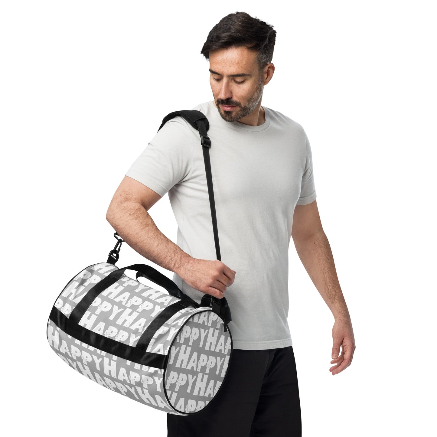 Man carrying gym bag adjustable removable padded shoulder strap Happy sponge print black white on grey small duffle bag HappyStuff Brand