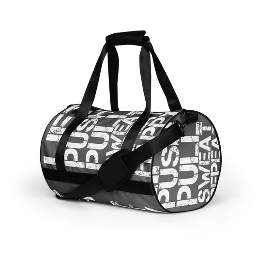 Gym bag slate grey and white all over print Lift Push Pull Sweat Repeat Happy small duffle bag black detail angled side view showing handles and strap HappyStuff Brand