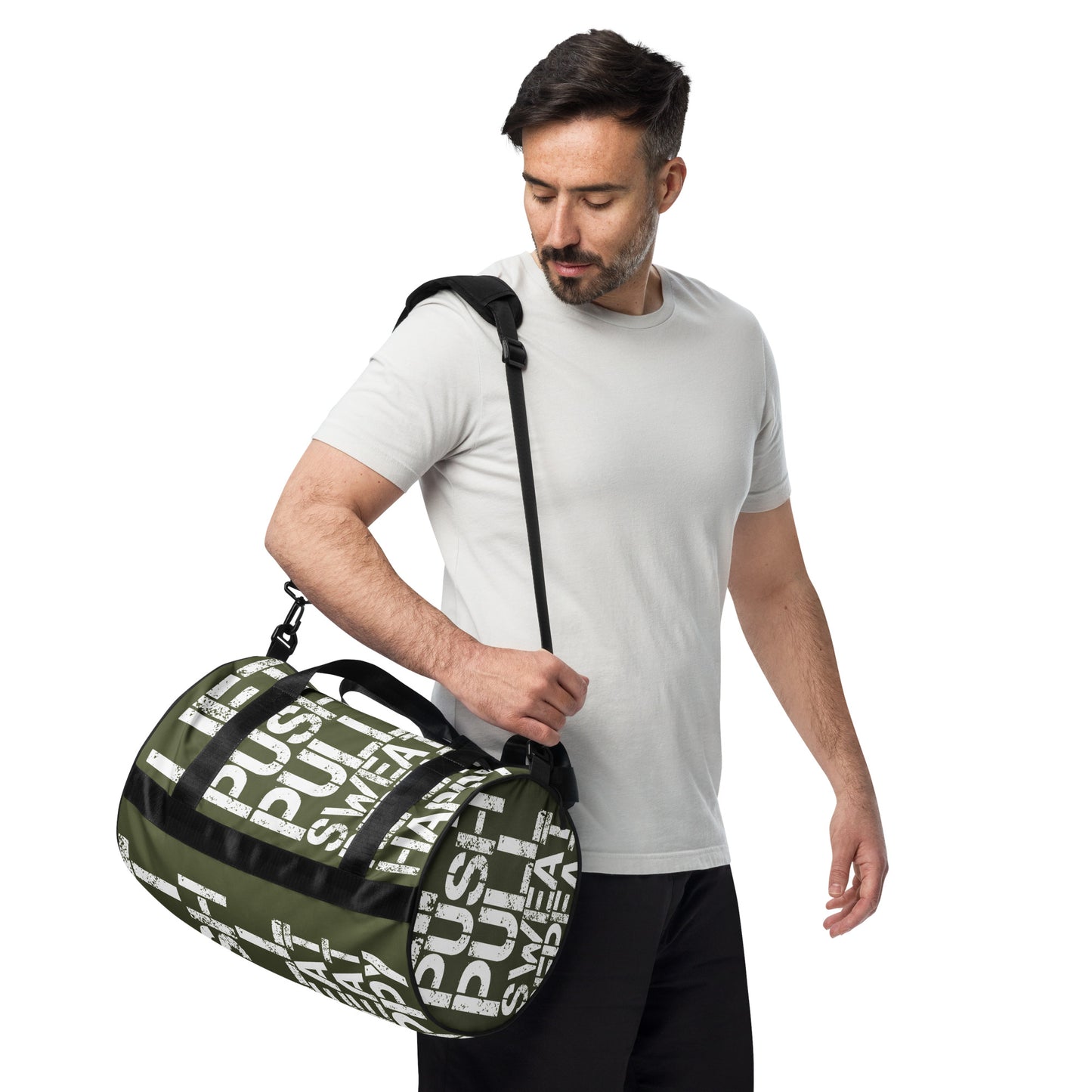 Man carrying gym bag adjustable removable padded shoulder strap HappyStuff Brand small duffle bag khaki green and white all over print Lift Push Pull Sweat Repeat Happy black detail