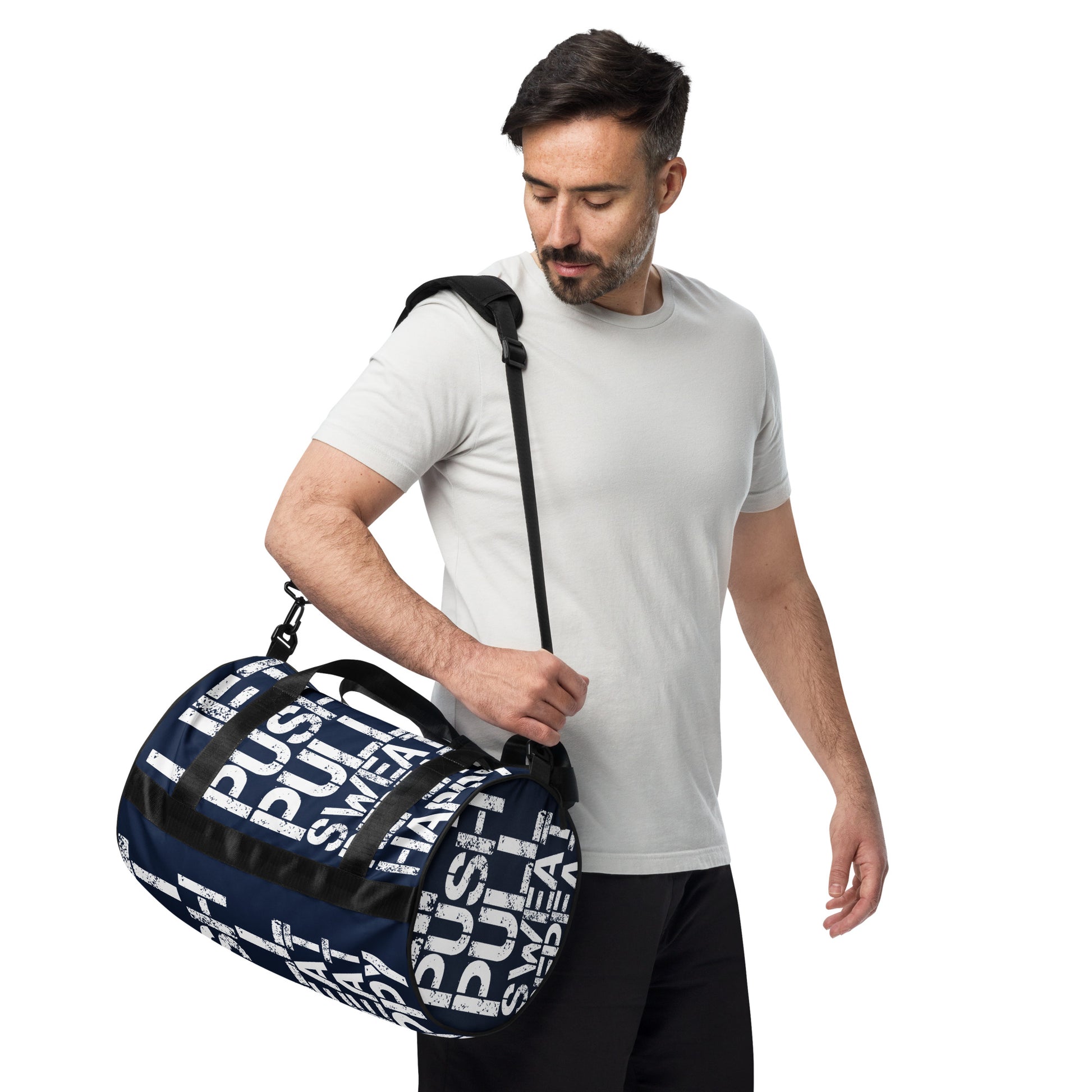 Man carrying gym bag adjustable removable padded shoulder strap HappyStuff Brand small duffle bag navy blue and white all over print Lift Push Pull Sweat Repeat Happy black detail