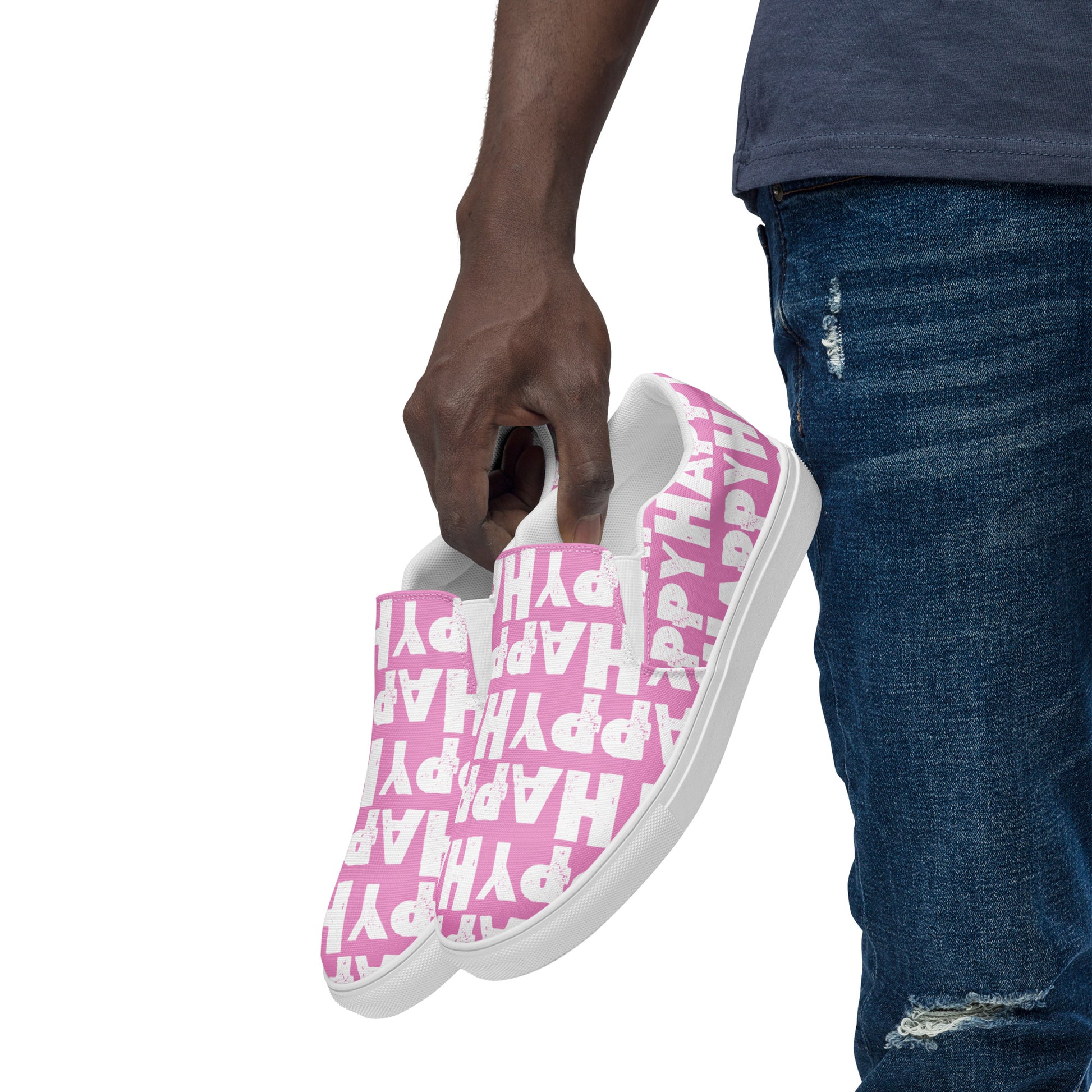 Mans hand holding happy shoes at his side fun pink and white sneakers Happy Sponge Printed HappyStuff canvas slip on shoes