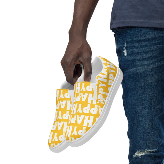 Mans hand holding happy shoes at his side fun yellow and white sneakers Happy Sponge Printed HappyStuff canvas slip on shoes