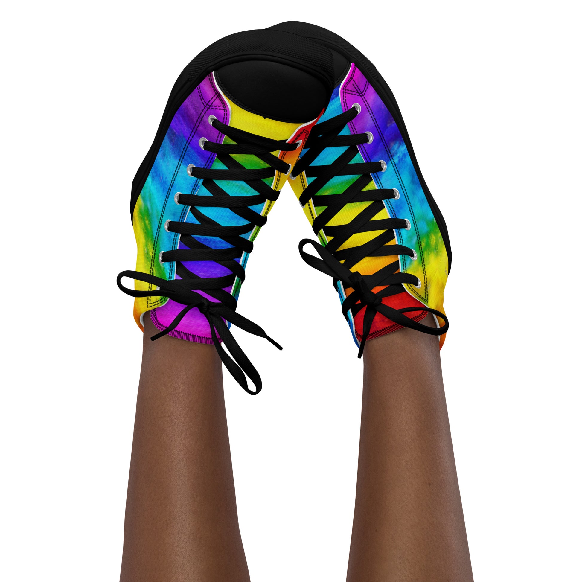 Feet in the air wearing womens sneakers tapping toes of her rainbow shoes holi colours printed on white high top sneakers black sole