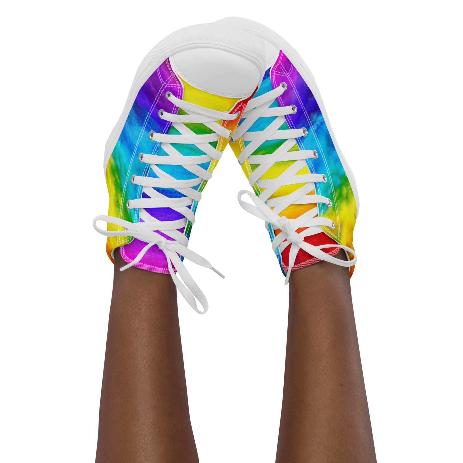 Feet in the air wearing womens sneakers tapping toes of her rainbow shoes holi colours printed on white high top sneakers