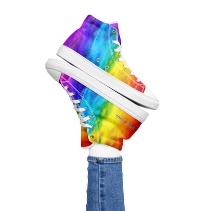 Womans right foot propping up rainbow shoes holi colours printed on white high top sneakers balancing left sneaker atop