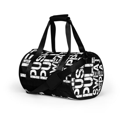 Gym bag black and white all over print Lift Push Pull Sweat Repeat Happy small duffle bag angled side view showing handles and strap HappyStuff Brand 